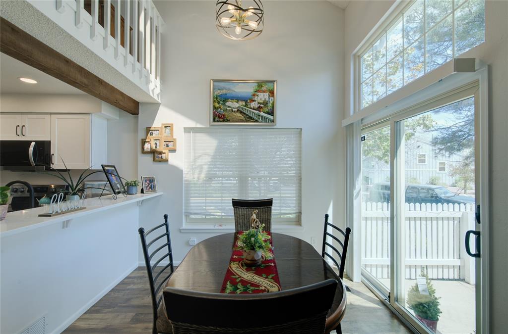 Image 6 of 21: Dining area with vaulted ceilings and wood-finish flooring