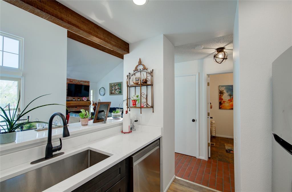 Image 9 of 21: Kitchen pass-through featuring an undermount sink with a matte black faucet
