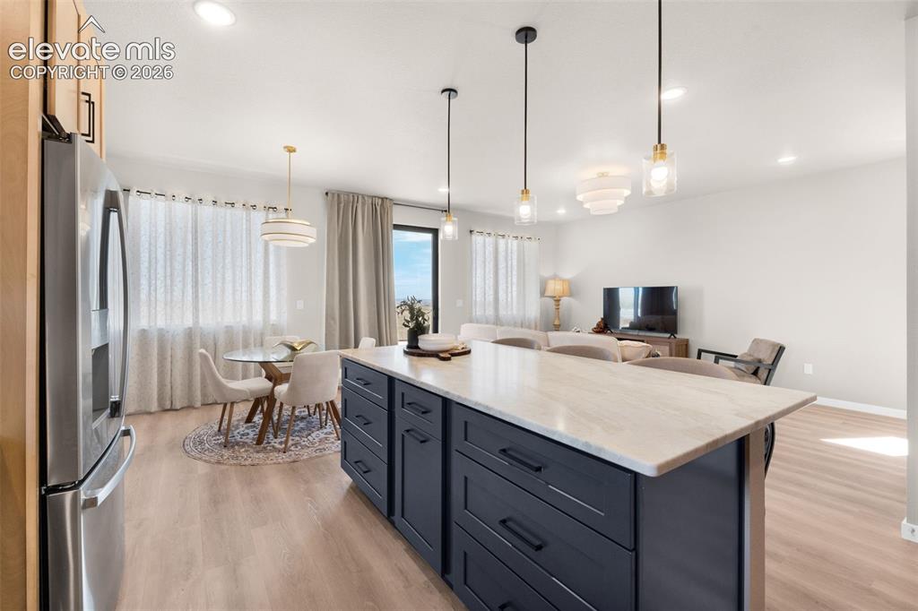 Image 10 of 36: Contemporary kitchen island with a light-toned countertop, dark-finish cabi