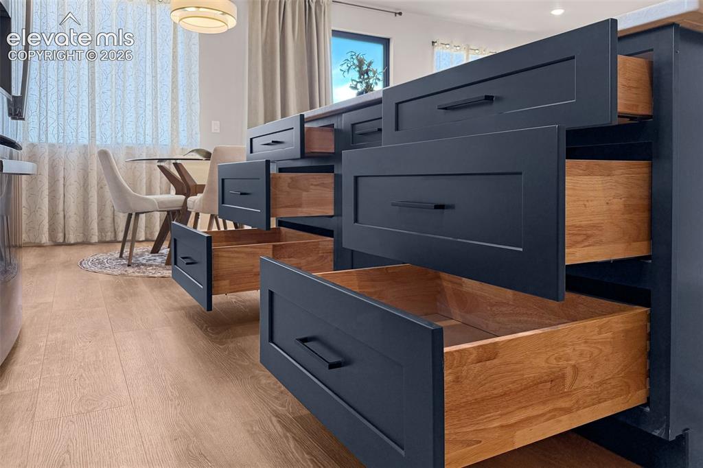 Image 11 of 36: Kitchen island featuring dark blue cabinetry with flat-panel drawer fronts