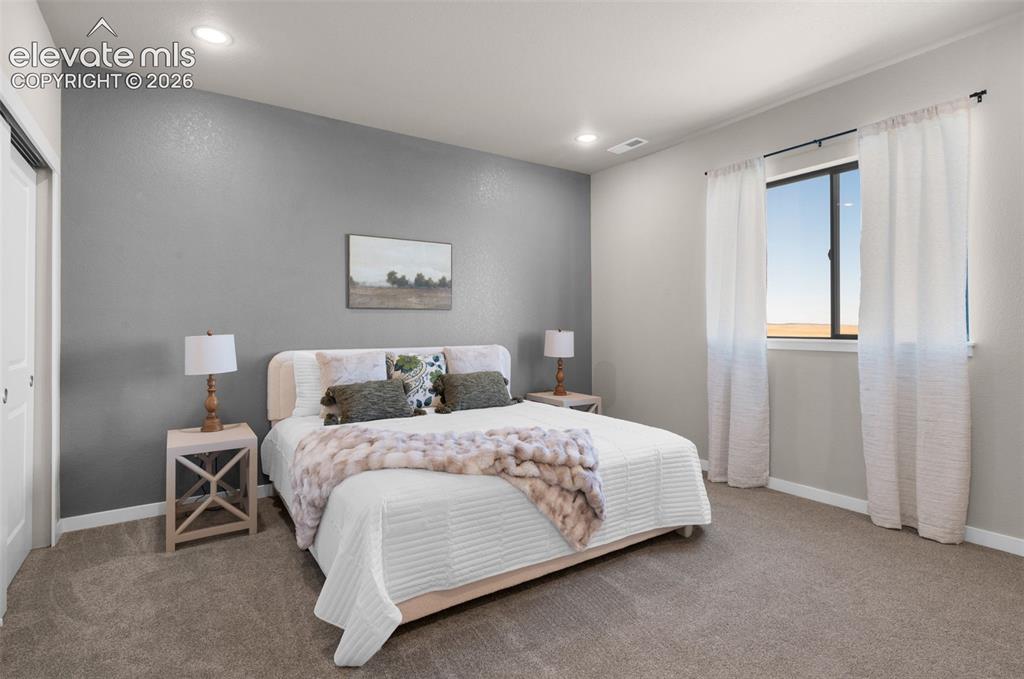 Image 17 of 36: Recessed lighting, neutral gray wall, white trim, carpeted flooring, and a
