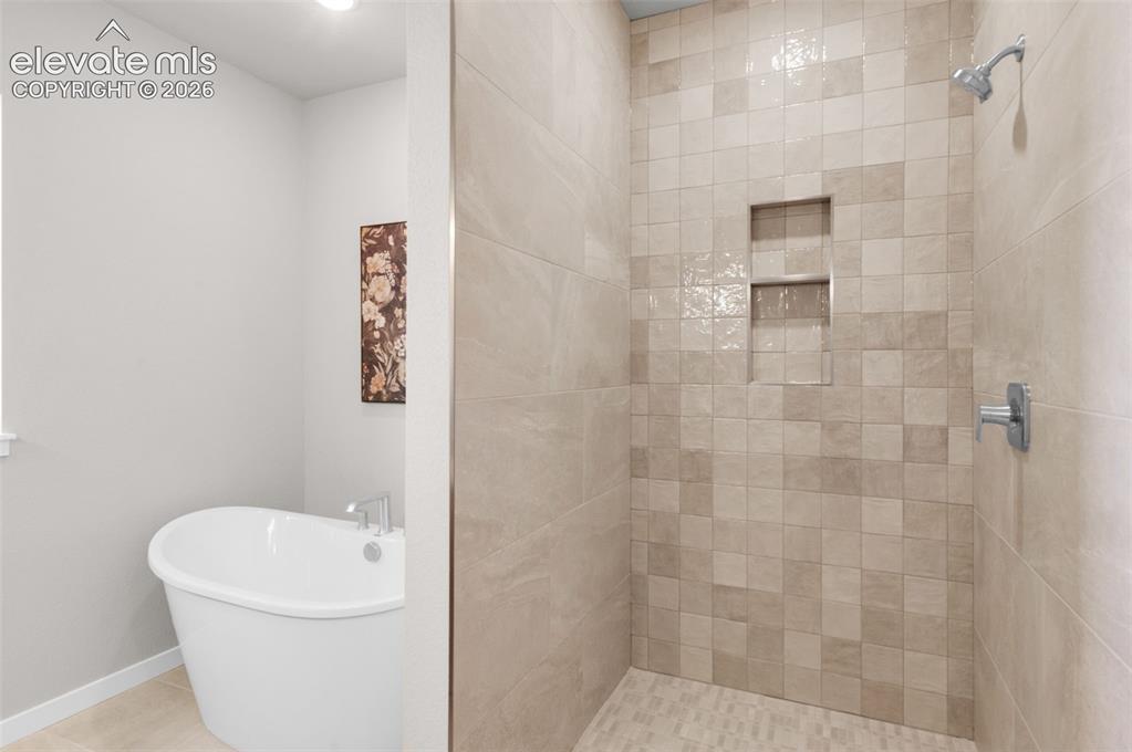 Image 21 of 36: Freestanding soaking tub, tiled walk-in shower, dual shower niches, chrome 
