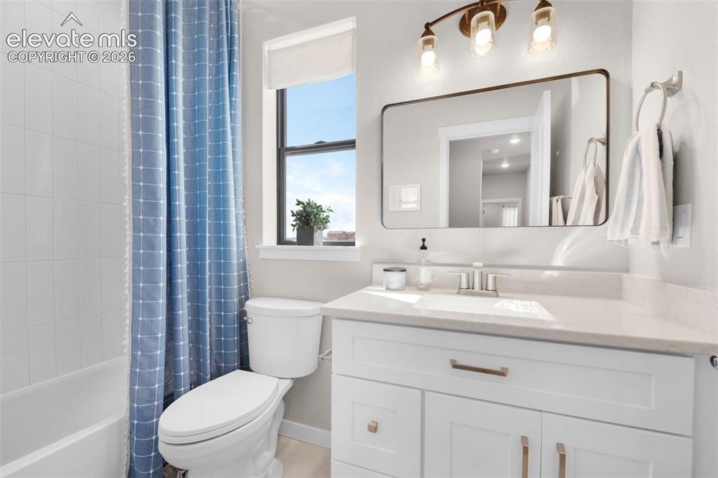 Image 29 of 36: White vanity with brushed nickel hardware, integrated sink, and light-toned