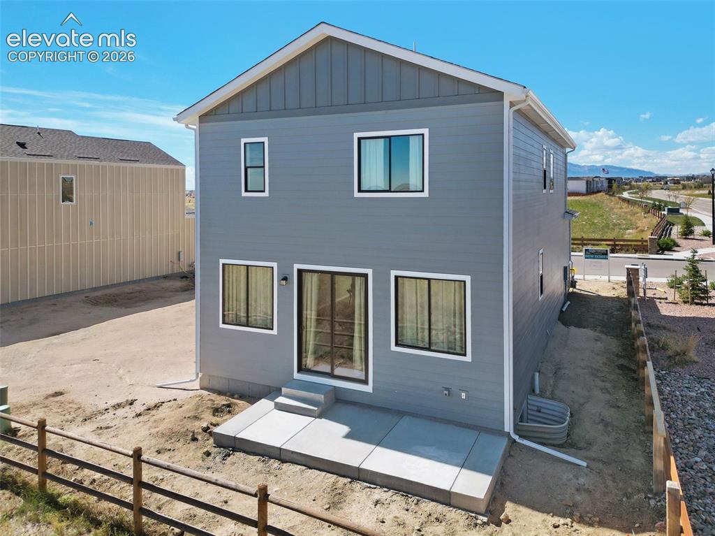 Image 32 of 36: Two-story exterior with horizontal siding and board-and-batten accents