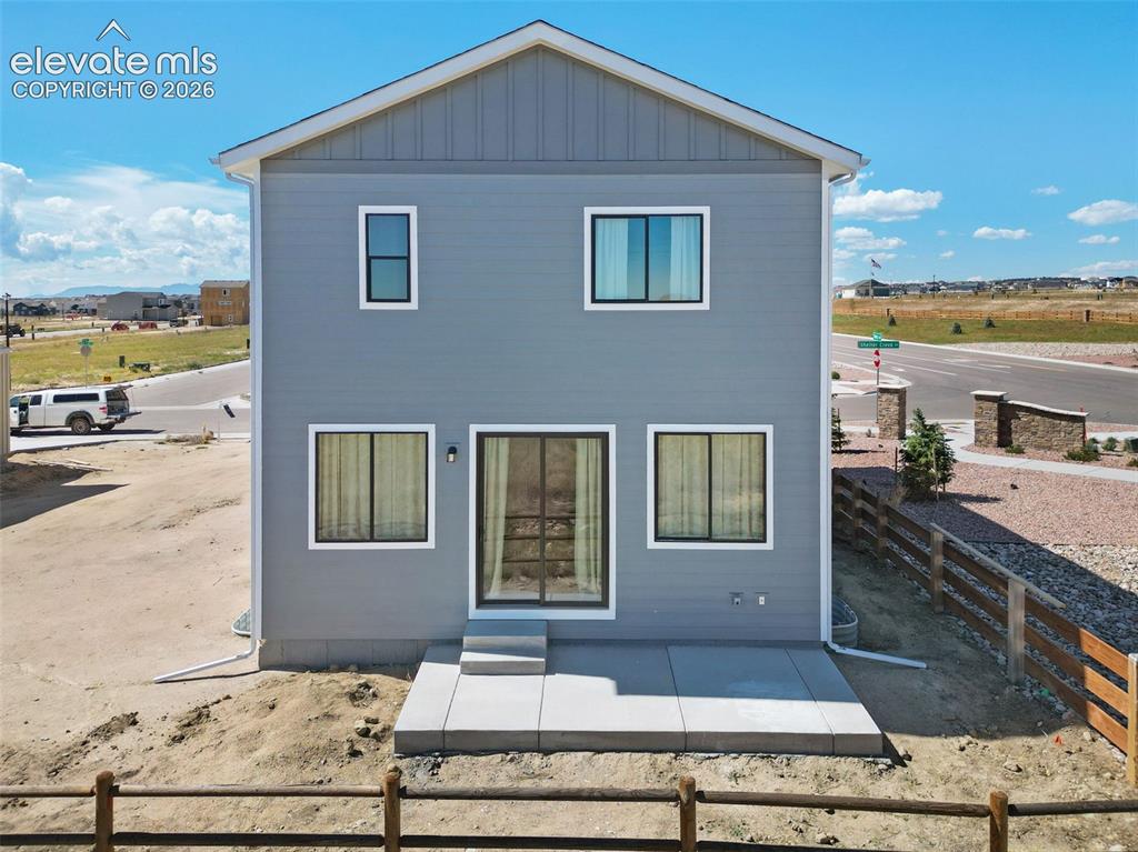 Image 33 of 36: Two-story exterior with horizontal siding and vertical paneling, featuring 