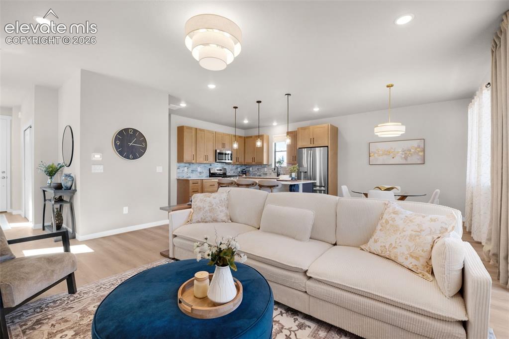 Image 6 of 36: Open-concept living area featuring light wood-finish flooring, recessed lig