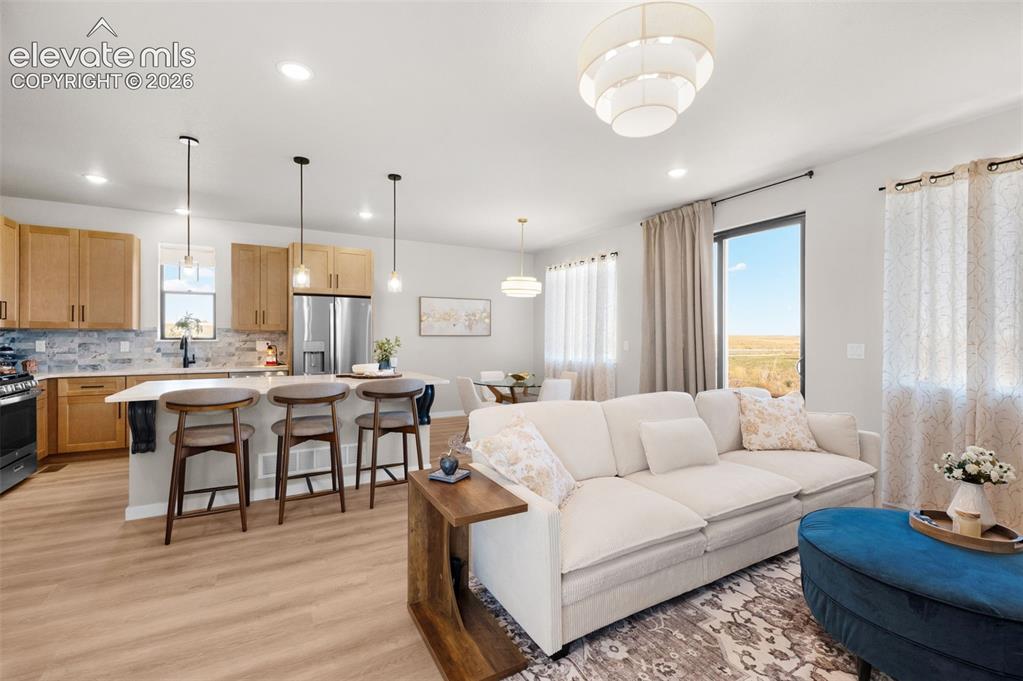 Image 7 of 36: Open concept living area with wood-finish flooring, recessed lighting, and 