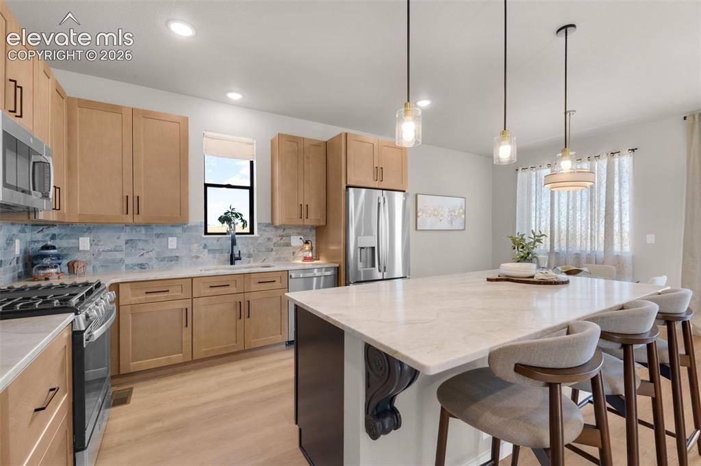 Image 9 of 36: Kitchen featuring light wood-finish cabinetry, stainless steel appliances, 