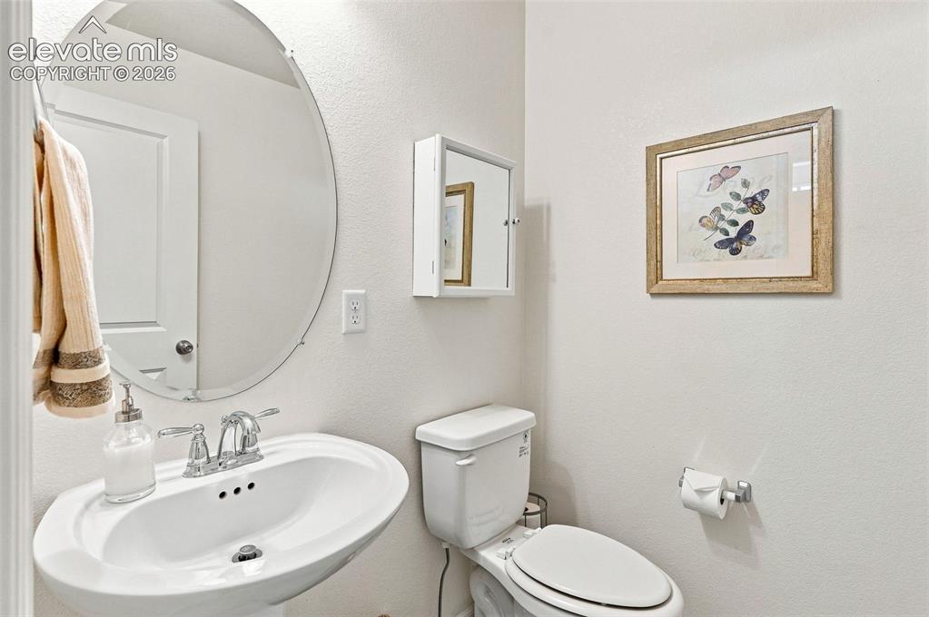 Image 13 of 39: Powder bath with pedestal sink and wood floors