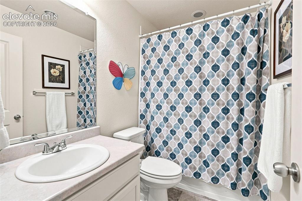 Image 21 of 39: Full secondary bath off hall with tile floor