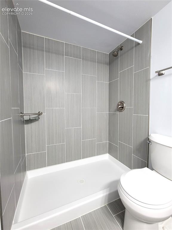 Image 15 of 31: Walk-in shower featuring light grey vertical plank tile, brushed nickel fix