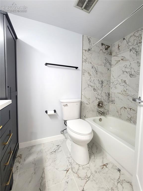 Image 19 of 31: Bathroom featuring a white bathtub with a shower, a modern toilet, and an e