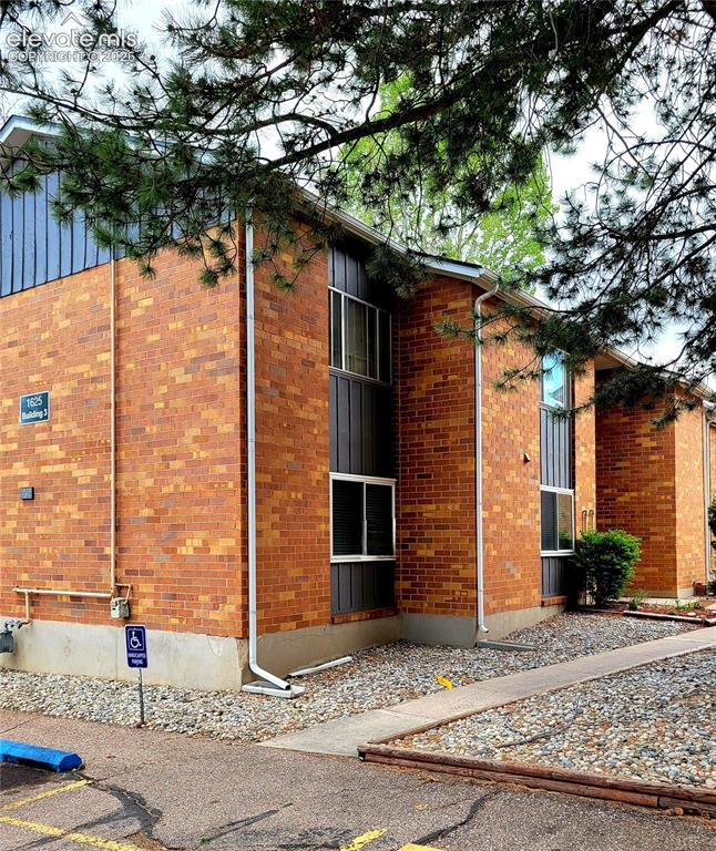Image 2 of 32: Brick building exterior featuring multi-paned windows, vertical dark siding