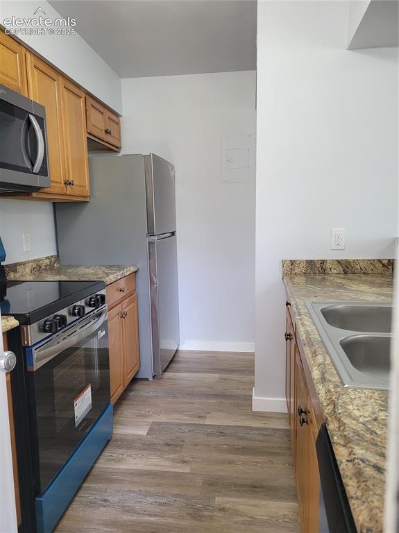 Image 25 of 31: Kitchen featuring wood-finish flooring, light wood cabinetry, stone-look co