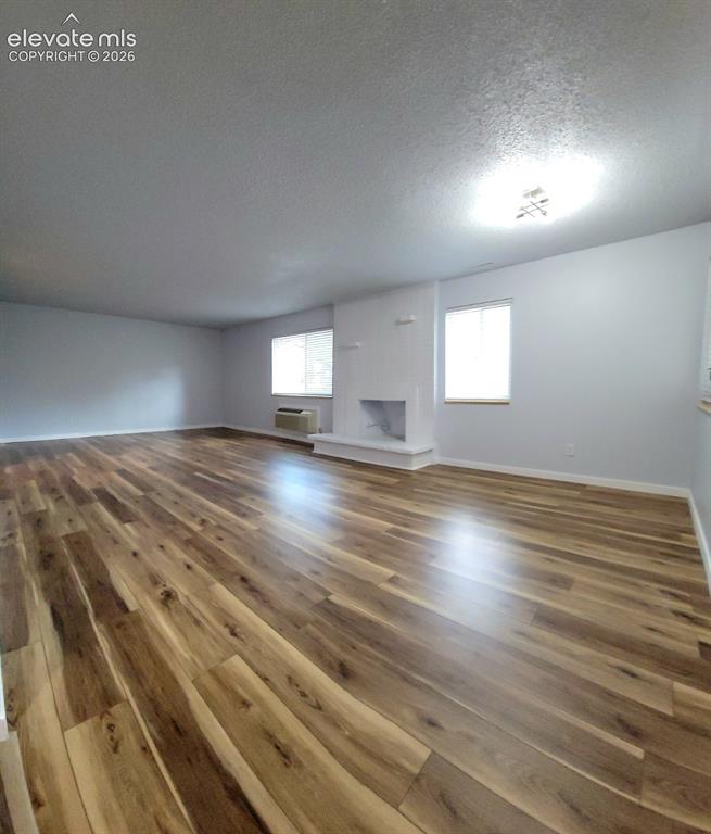 Image 28 of 31: Spacious living area featuring wood-finish flooring throughout