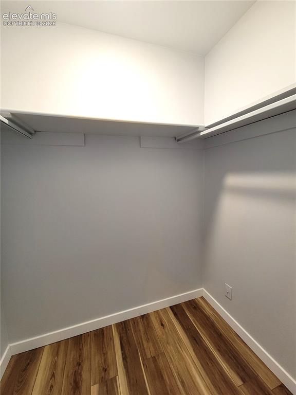 Image 29 of 32: Walk-in closet featuring wood-finish flooring, white baseboards, light gray