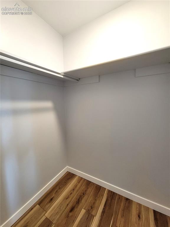 Image 30 of 32: Walk-in closet featuring wood-finish flooring, white baseboards, light gray