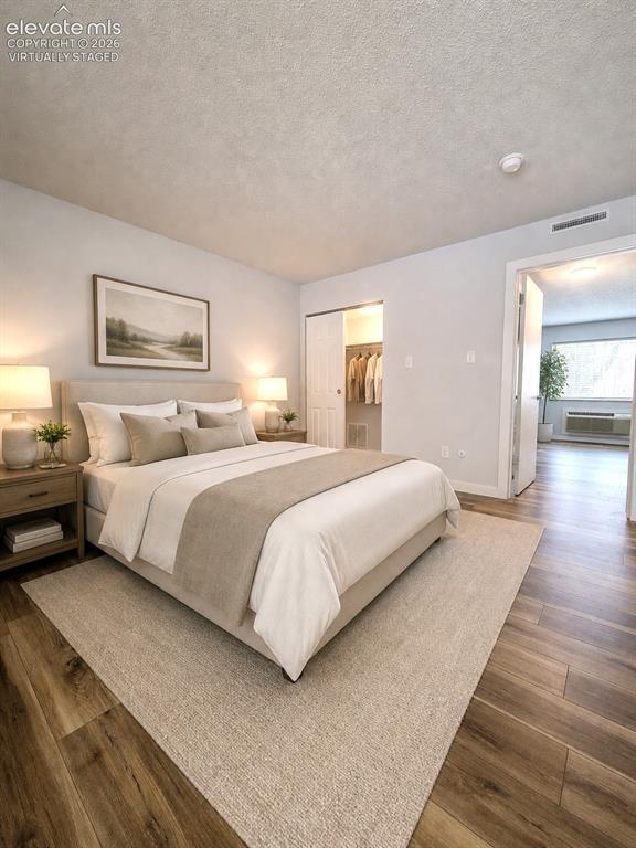 Image 6 of 32: Virtually staged Bedroom featuring wood-finish flooring, a textured ceiling