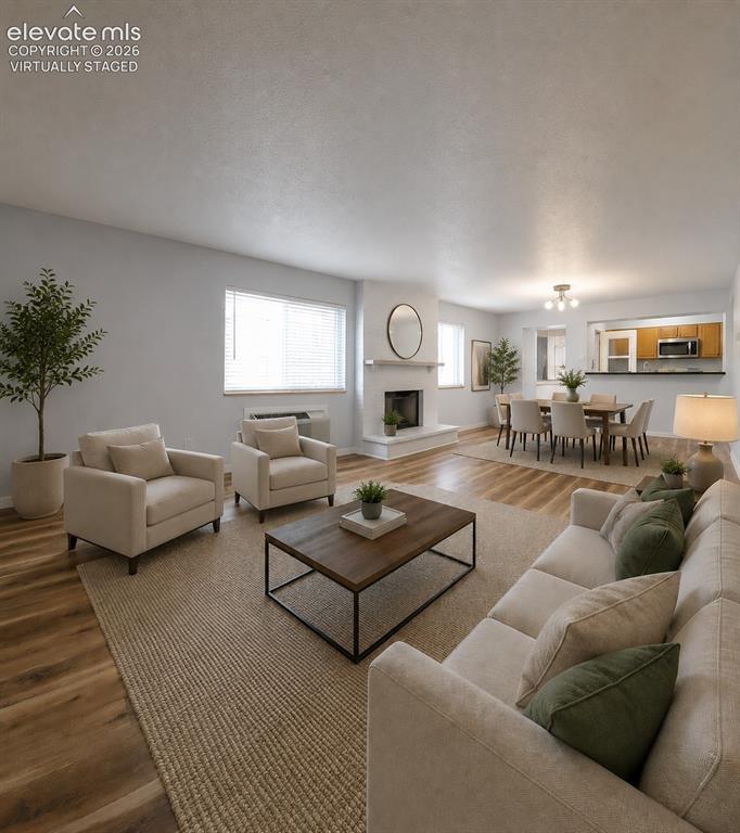 Image 6 of 31: Virtually staged Spacious living area featuring wood-finish flooring throug