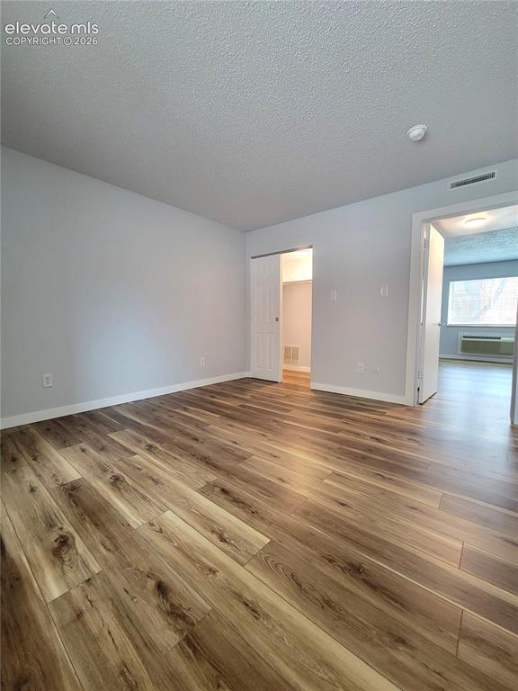 Image 7 of 32: Spacious interior featuring wood-finish flooring, light grey wall paint, an