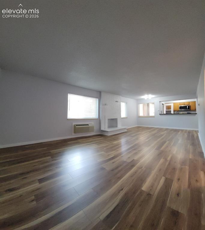 Image 7 of 31: Spacious living area featuring wood-finish flooring throughout
