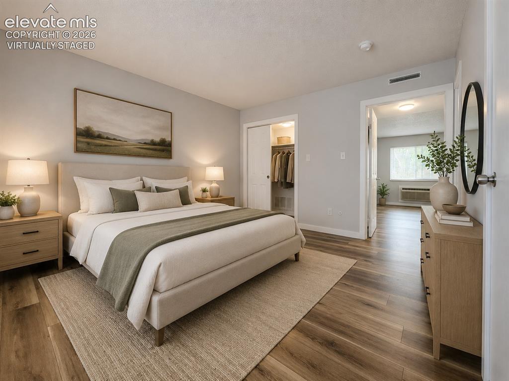 Image 8 of 31: Virtually staged Primary Bedroom featuring wood-finish flooring, and his &
