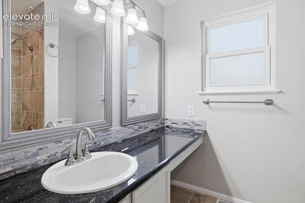 Image 10 of 33: Primary Bathroom with Granite Countertop and Tiled Shower & Tub!