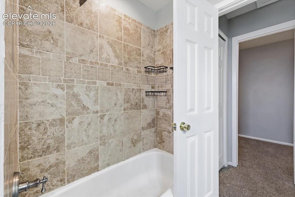 Image 11 of 33: Primary Bathroom with Granite Countertop and Tiled Shower & Tub!