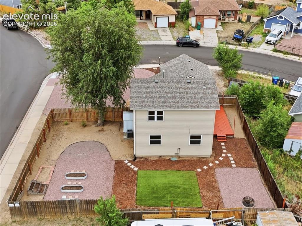 Image 22 of 33: Xeriscaped Fenced Backyard with Firepit, Turf, Raised Garden Boxes, and Sto