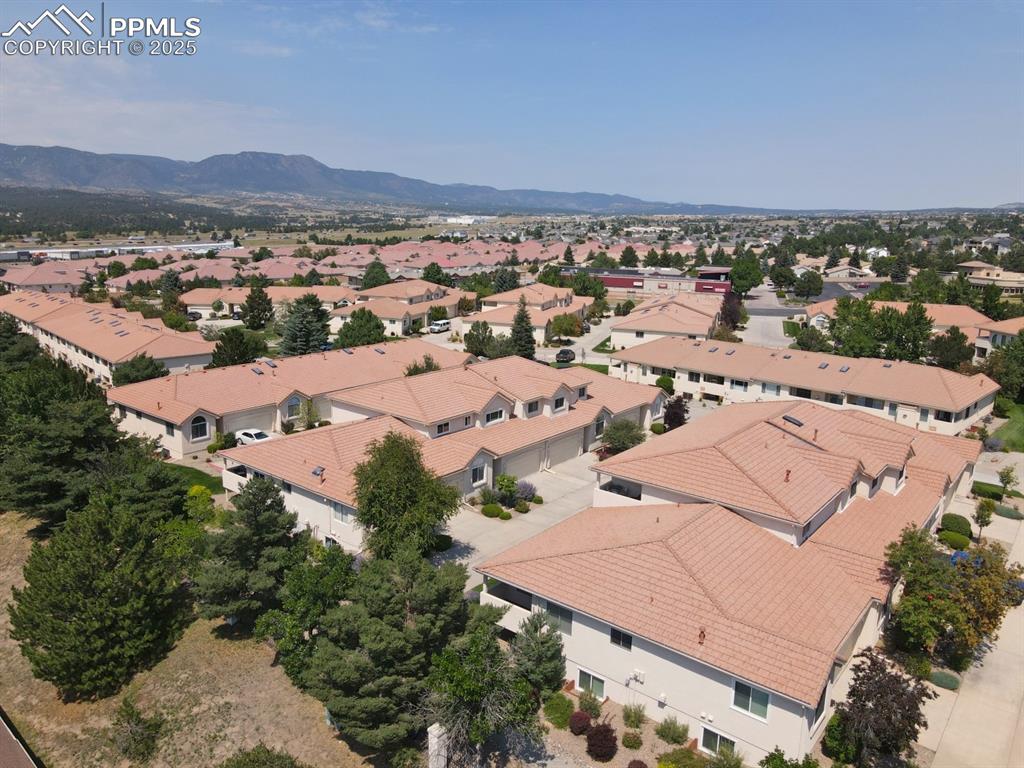 Image 37 of 41: Aerial view of residential area with a mountainous background