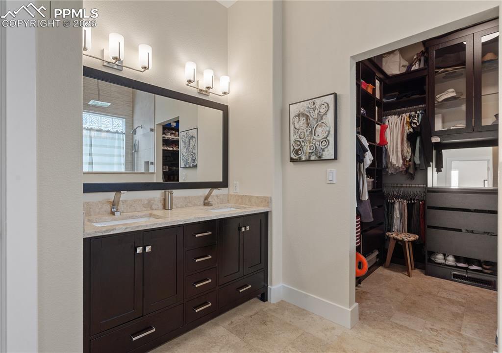 Image 22 of 50: Double sinks and Closet Factory walk in closet in master bathroom