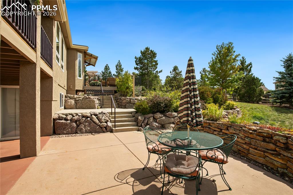 Image 42 of 50: Backyard patio with beautiful low maintenance landscaping, mature trees