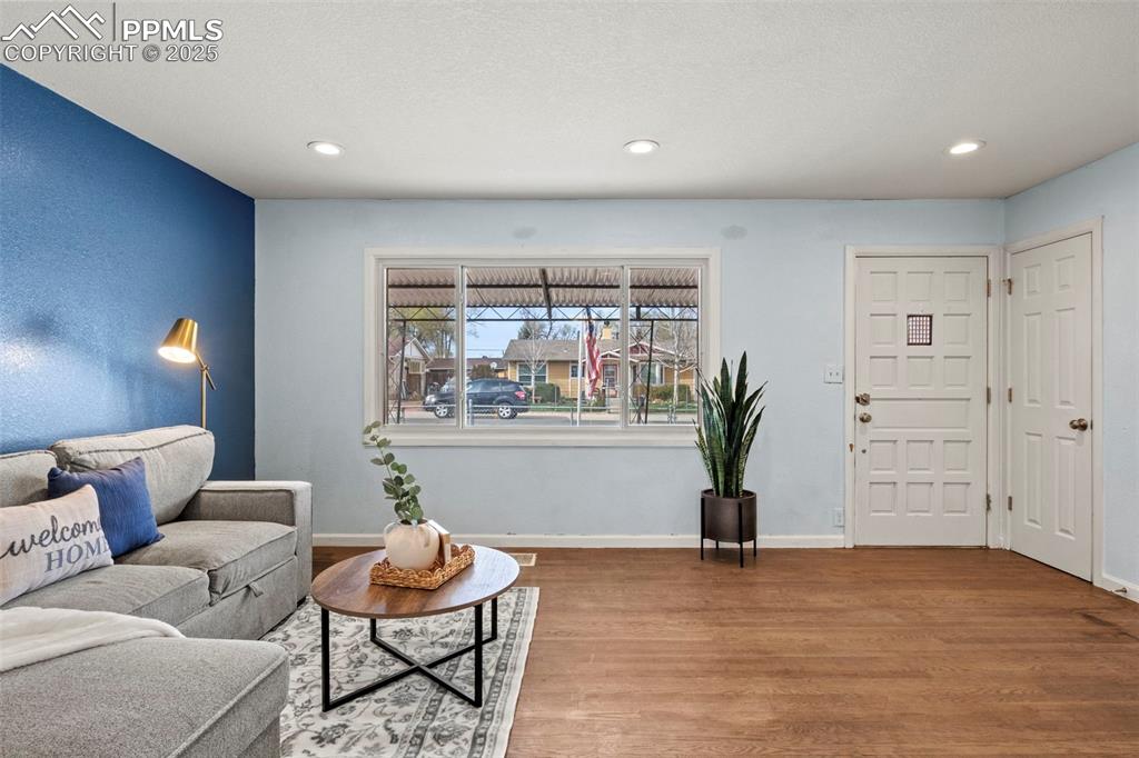 Image 11 of 39: Living area featuring baseboards, wood finished floors, and recessed lighti