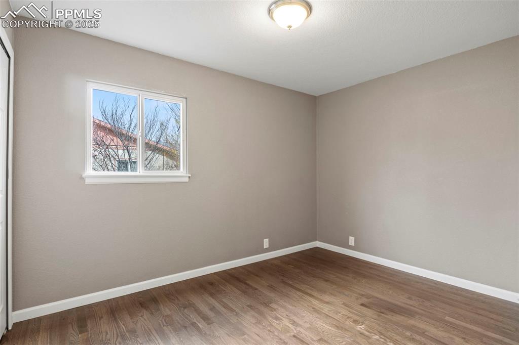 Image 28 of 39: Spare room featuring baseboards and wood finished floors