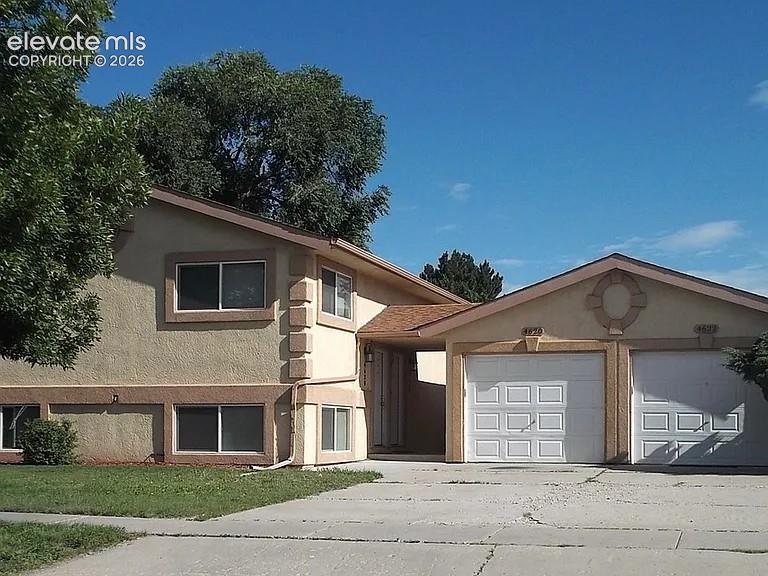Caption: Split-level residence featuring a stucco exterior