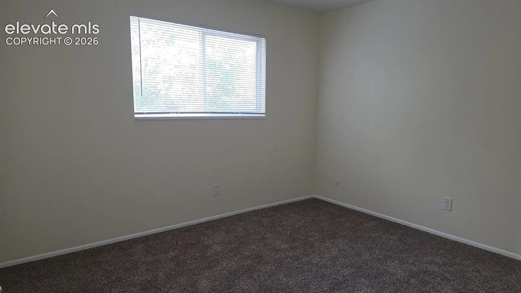 Image 5 of 5: Carpeted interior space featuring a single window with blinds and light-ton