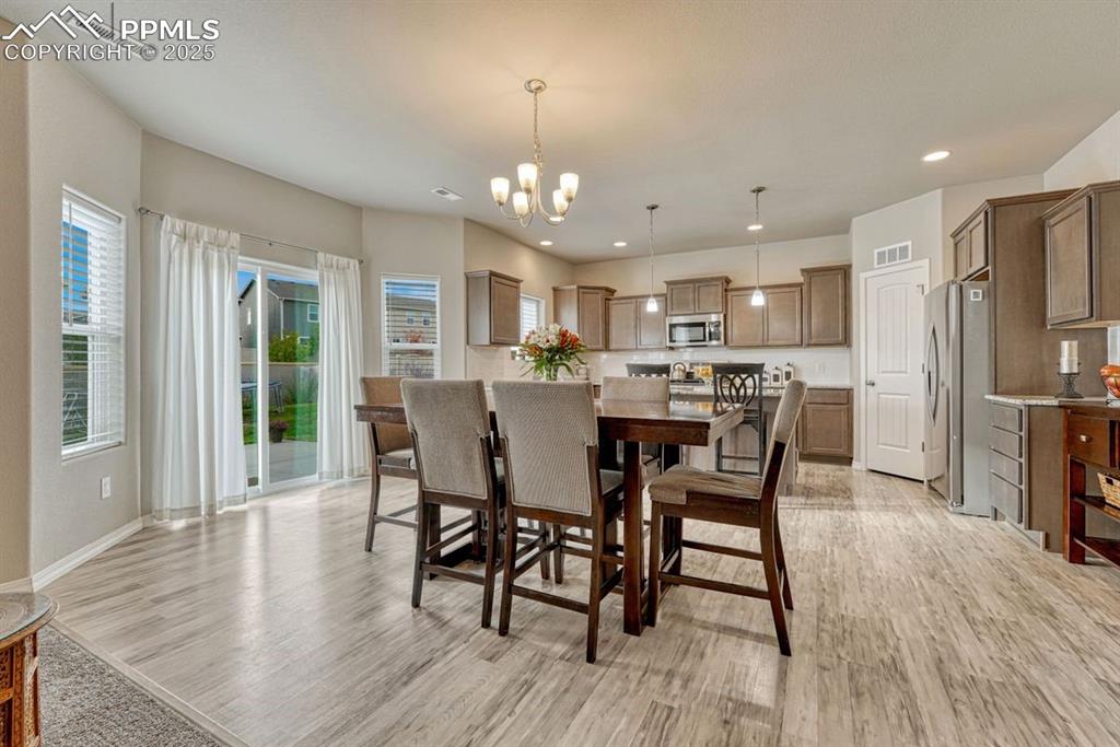 Image 14 of 40: The dining area is just steps from the kitchen and has easy access to the p