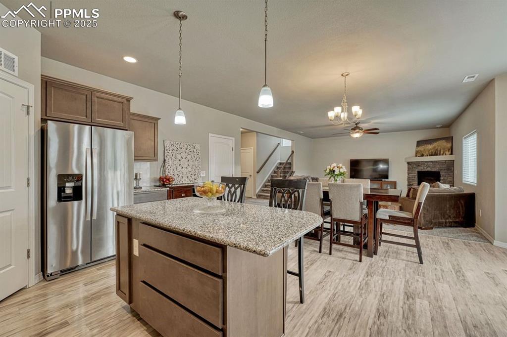 Image 18 of 40: The great room with kitchen, dining and living spaces, is the heart of the 