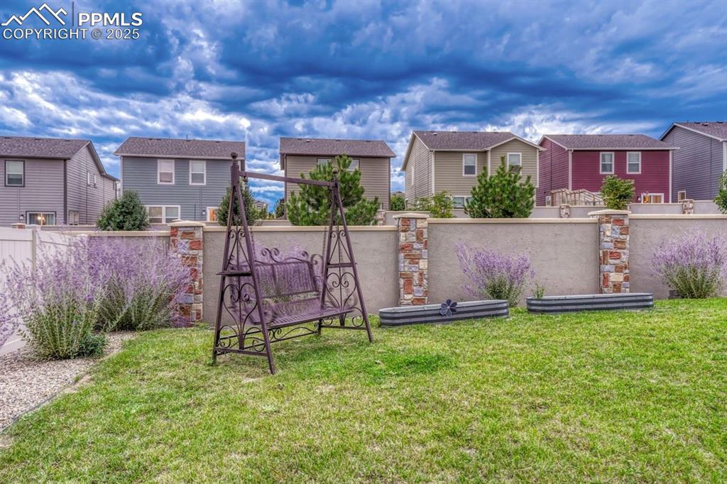 Image 31 of 40: The backyard is currently planted with established Russian sage and offers 