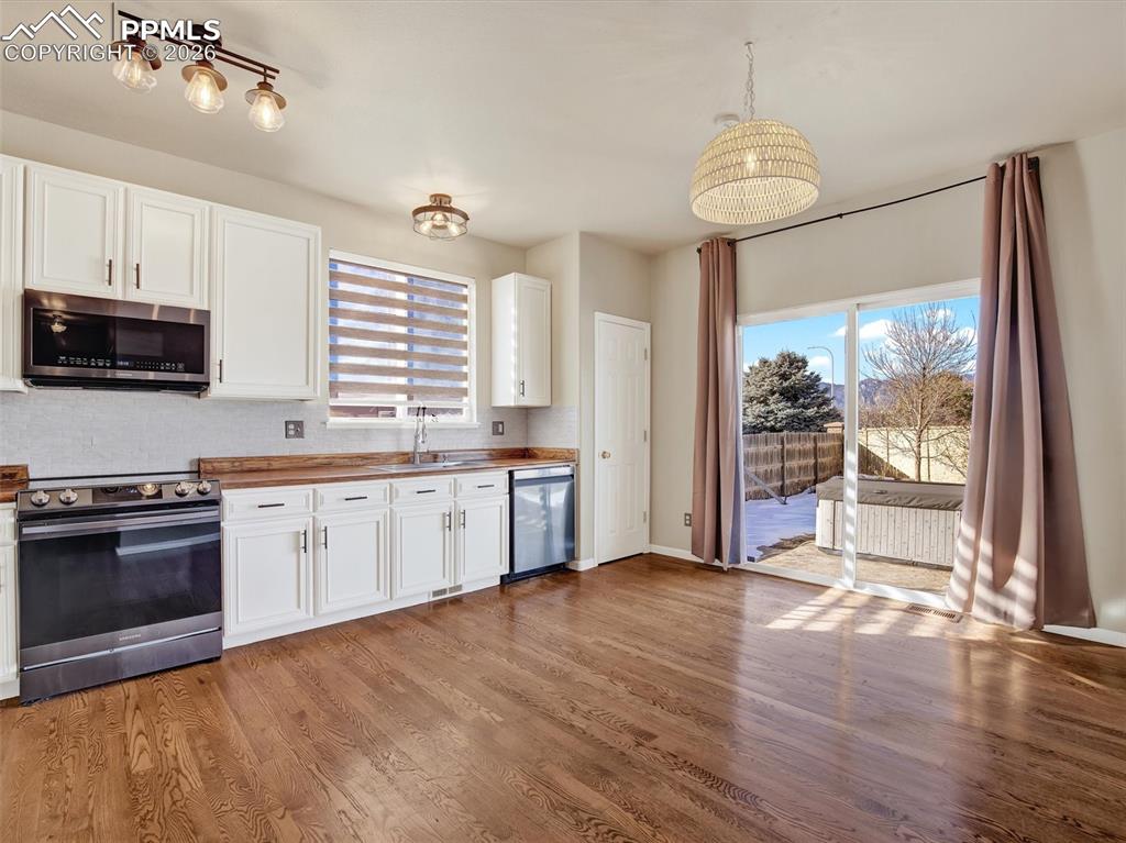 Image 11 of 49: Open kitchen, eat-in dining area with updated appliances and walk out slidi