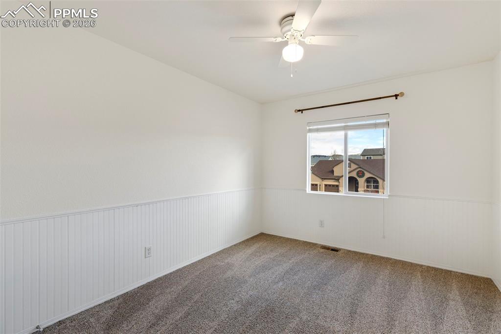 Image 19 of 31: Carpeted spare room featuring wainscoting and ceiling fan