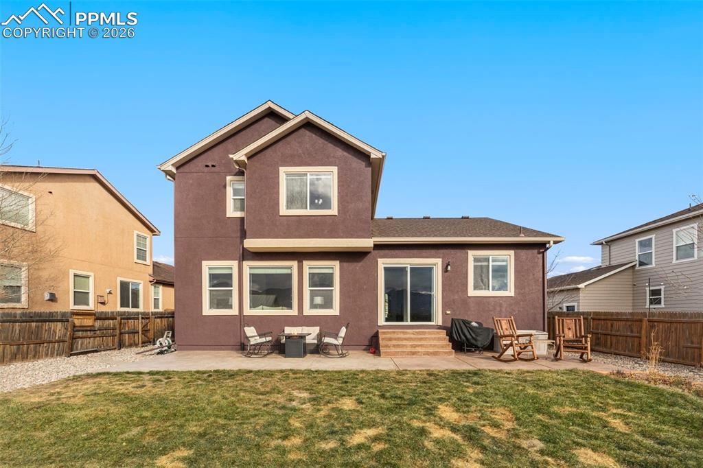 Image 28 of 31: Back of property with entry steps, a patio area, stucco siding, and a fence