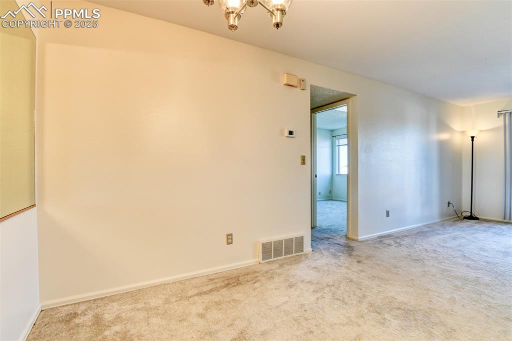 Image 12 of 42: Unfurnished room featuring carpet floors and a chandelier