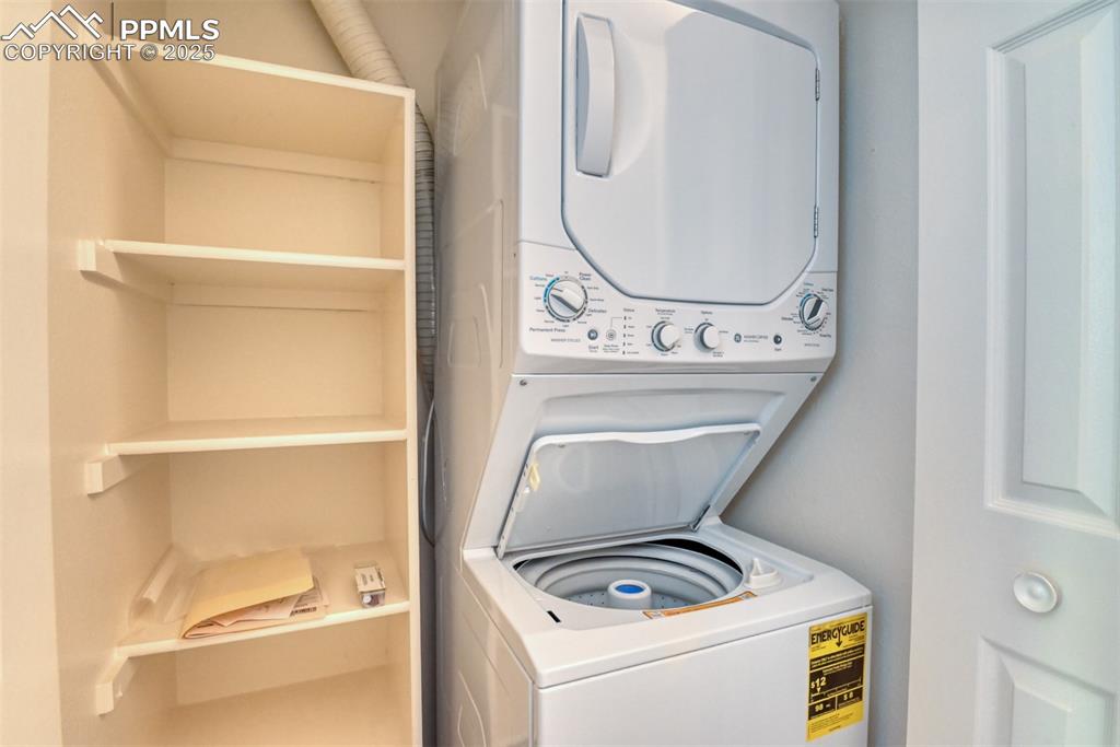 Image 22 of 42: Laundry area featuring stacked washer and clothes dryer