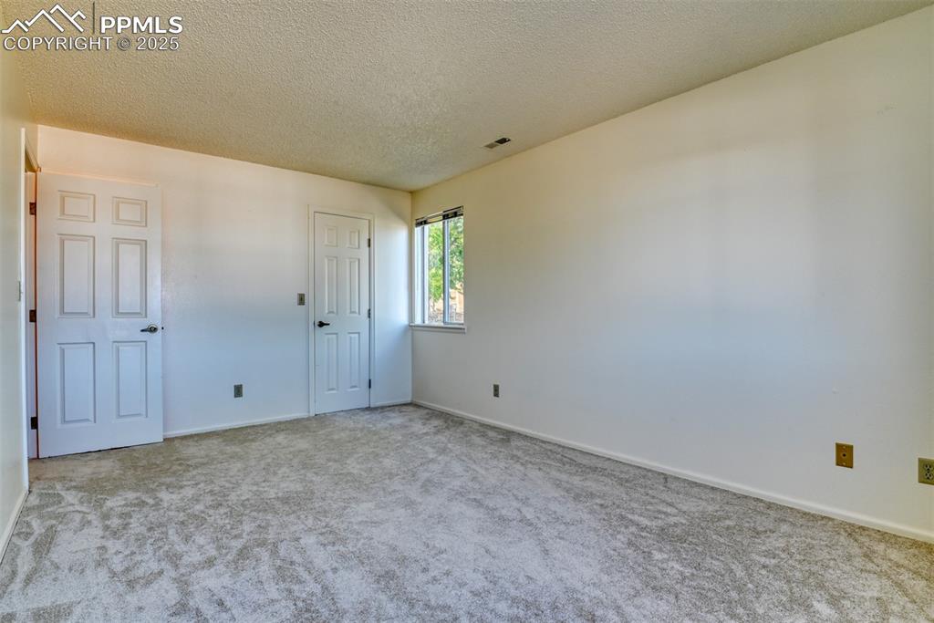 Image 24 of 42: Unfurnished bedroom with carpet flooring and a textured ceiling