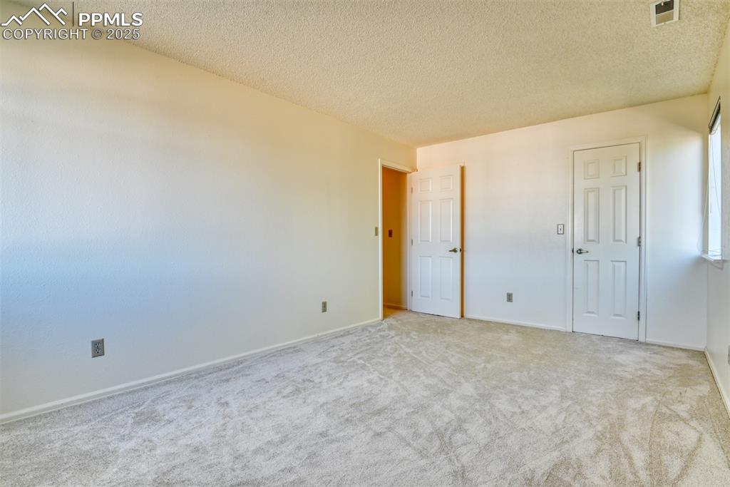 Image 25 of 42: Unfurnished bedroom with a textured ceiling and carpet