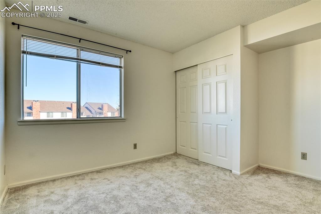 Image 31 of 42: Unfurnished bedroom with carpet floors, a textured ceiling, and a closet