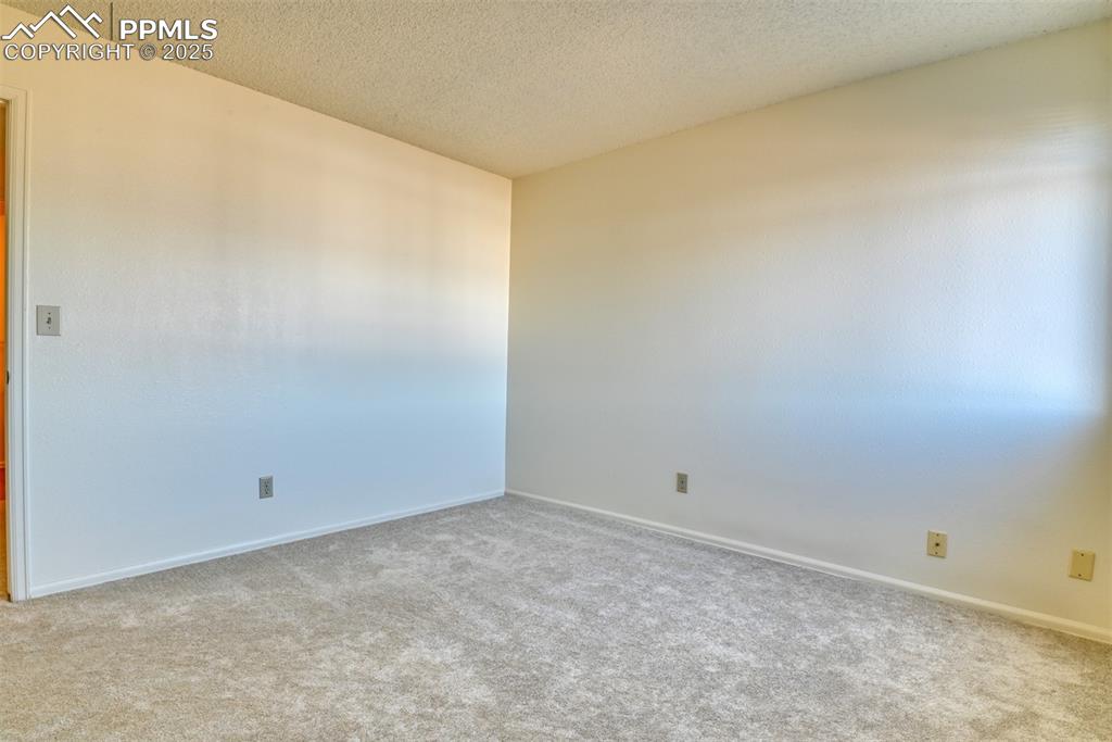 Image 33 of 42: Empty room featuring a textured ceiling and carpet flooring