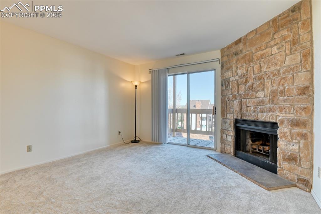 Image 5 of 42: Unfurnished living room with a fireplace and carpet
