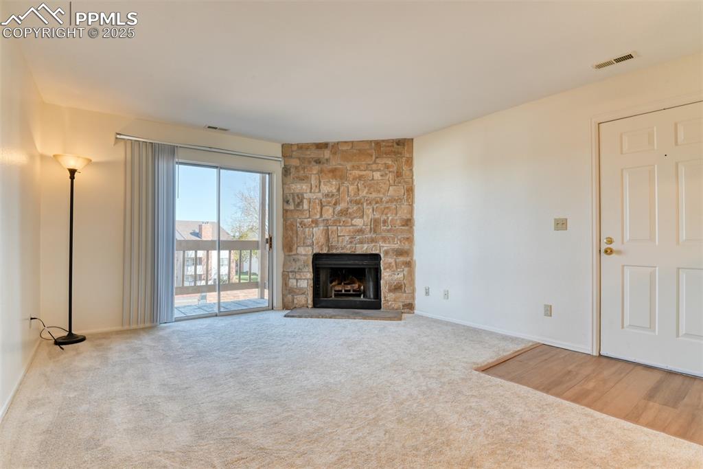 Image 6 of 42: Unfurnished living room featuring a fireplace and light colored carpet
